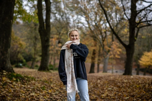 Teenage girl wearing scarf and smiling in a park
