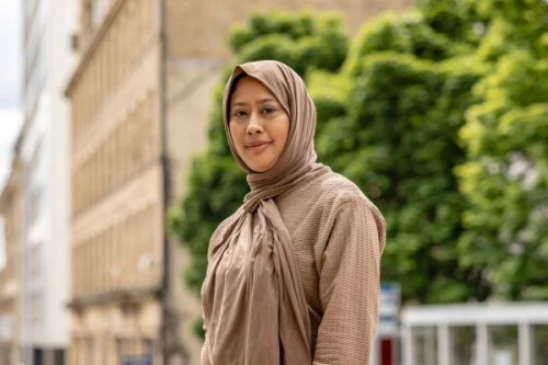 Woman in headscarf smiling in street