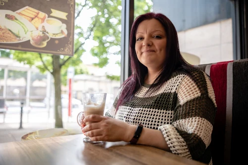 Woman by window in cafe drinking coffee