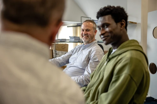 Two men sitting on chairs smiling