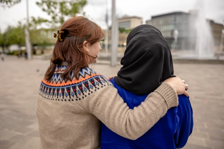 Woman standing in front of fountains in Bradford with arm around another woman